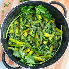 asparagus and parsley in a pan on a cutting board