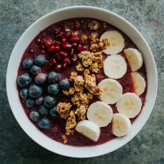 a bowl filled with fruit and granola on top of a table