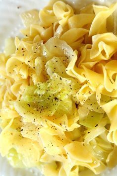 pasta with broccoli and seasoning in a white bowl on top of a table
