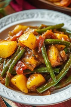a white plate topped with green beans and potatoes