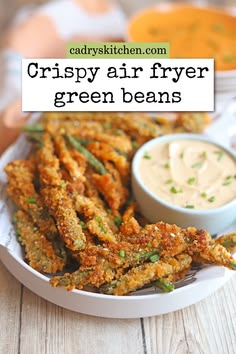 crispy air fryer green beans on a plate with dipping sauce in the background