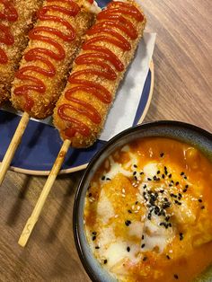 two plates with food on them and chopsticks next to one bowl of soup