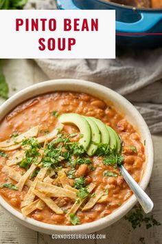 a bowl of pinto bean soup with avocado and tortilla chips on the side
