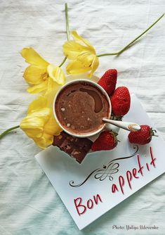 a bowl of chocolate with strawberries and flowers