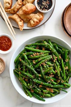 green beans in a bowl with chopsticks and dipping sauce