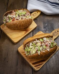 two wooden cutting boards with sandwiches on them