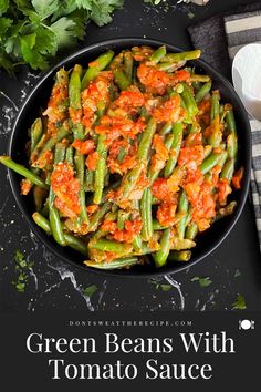 green beans with tomato sauce in a black bowl