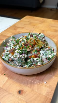 a bowl filled with salad sitting on top of a wooden table