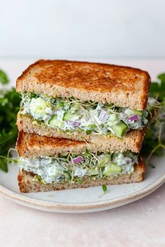 a sandwich with cucumber, lettuce and mayonnaise on toasted bread