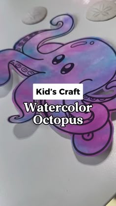 a purple octopus is sitting on top of a table with the words kid's craft watercolor octopus