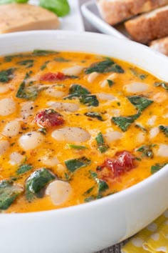 a white bowl filled with soup next to bread