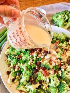 someone is pouring dressing into a plate of broccoli and celery salad