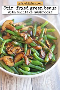 stir fried green beans with shiitake mushrooms in a white bowl on a wooden table