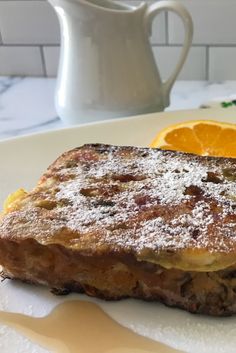 a piece of food sitting on top of a white plate next to an orange slice