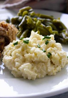mashed potatoes and green beans on a white plate