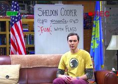 a man sitting on top of a brown couch in front of a whiteboard with writing