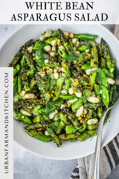 white bean asparagus salad in a bowl with a spoon and napkin on the side
