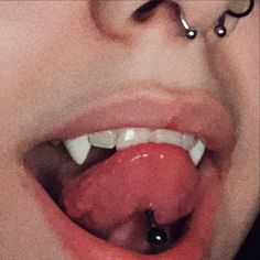 a woman with piercings on her nose has a tongue ring attached to it's lip