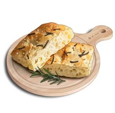 two pieces of bread on a plate with rosemary sprigs