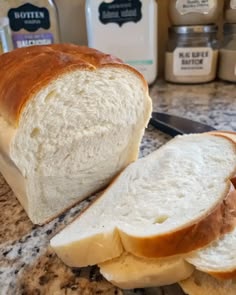 a loaf of bread sitting on top of a counter next to butter and jelly bottles