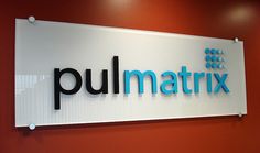 a sign that says pullmattrixx hanging on the wall in front of a red wall