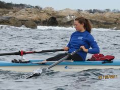 a woman sitting on top of a kayak in the ocean