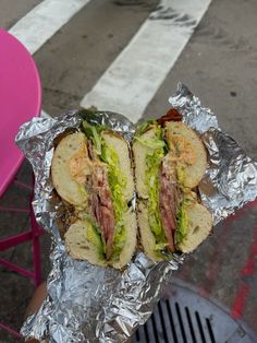 the sandwich is wrapped in tin foil and ready to be eaten on the street side