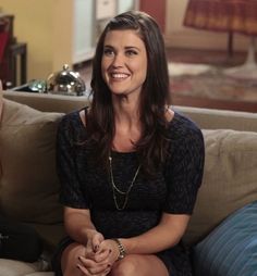 a woman sitting on top of a couch smiling