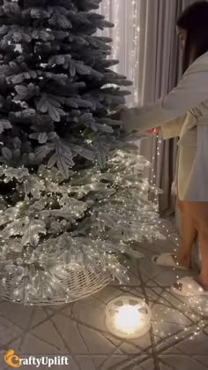 a woman standing in front of a christmas tree