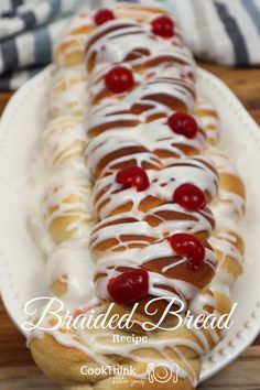 a white plate topped with a long pastry covered in icing and cherries