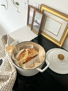 a pan with some bread in it sitting on a table next to a framed picture