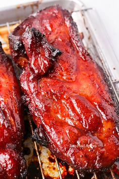 two barbecue ribs are being cooked on the grill