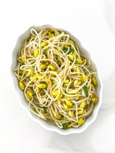 a white bowl filled with pasta and corn