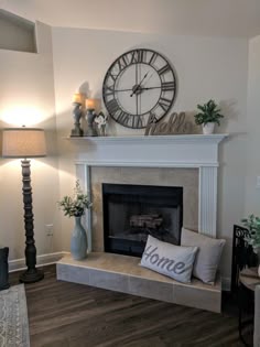 a living room filled with furniture and a large clock on the wall above the fireplace