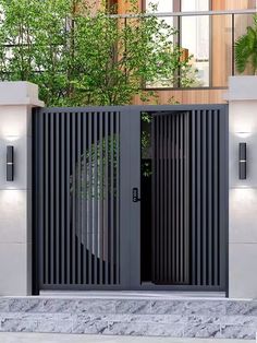 an entrance to a building with two black gates on each side and trees in the background