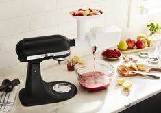 a kitchen counter topped with fruit and a mixer