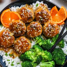 meatballs and broccoli on rice with orange slices in a bowl next to chopsticks