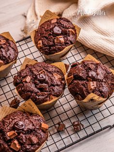 four chocolate muffins sitting on a cooling rack