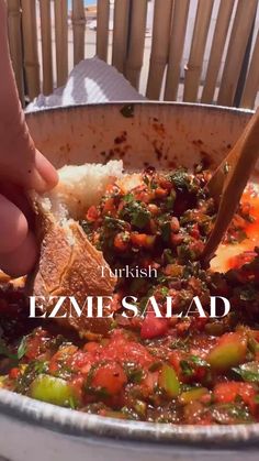 a person is eating some food with a spoon in their hand and the words turkish ezemesalad above it