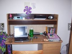 a laptop computer sitting on top of a wooden desk next to a bookshelf