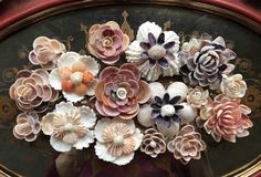 there are many flowers in the vase on the table top, and one is made out of clay