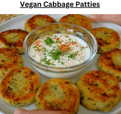 a white plate topped with crab cakes next to a bowl of dip