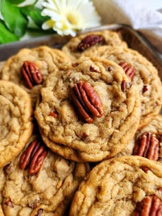 a pile of cookies with pecans on top