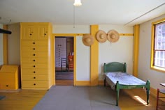a bedroom with yellow painted walls and furniture