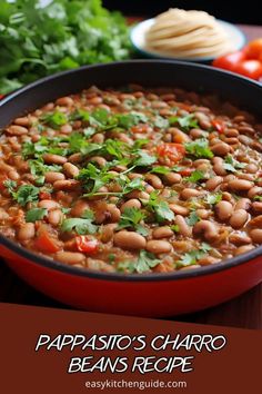 a red pot filled with beans and cilantro on top of a wooden table