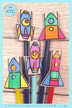 four colorful pencils in the shape of rockets on a wooden background with text overlay