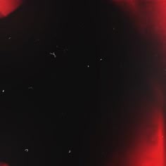 a black and red background with small white dots on the bottom right side of the image