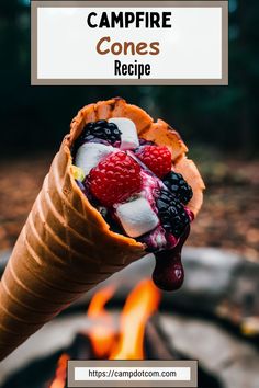 an ice cream cone filled with berries and marshmallows