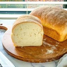 a loaf of bread sitting on top of a wooden cutting board