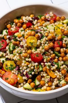 a white bowl filled with vegetables and grains